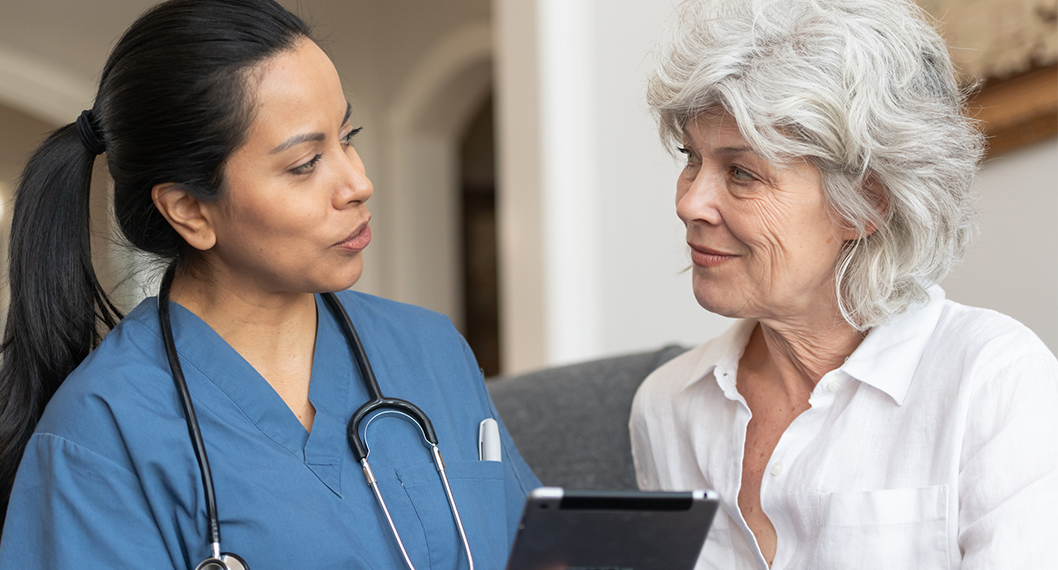 Female Doctor explaining the differences between Medicare vs Medicaid to an older woman 